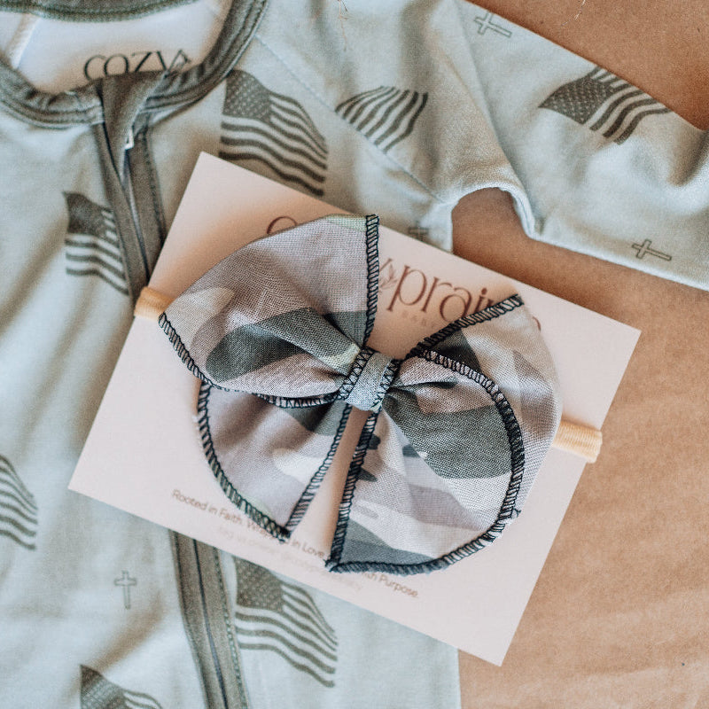 Baby outfit with long sleeves and a bow on a brown surface