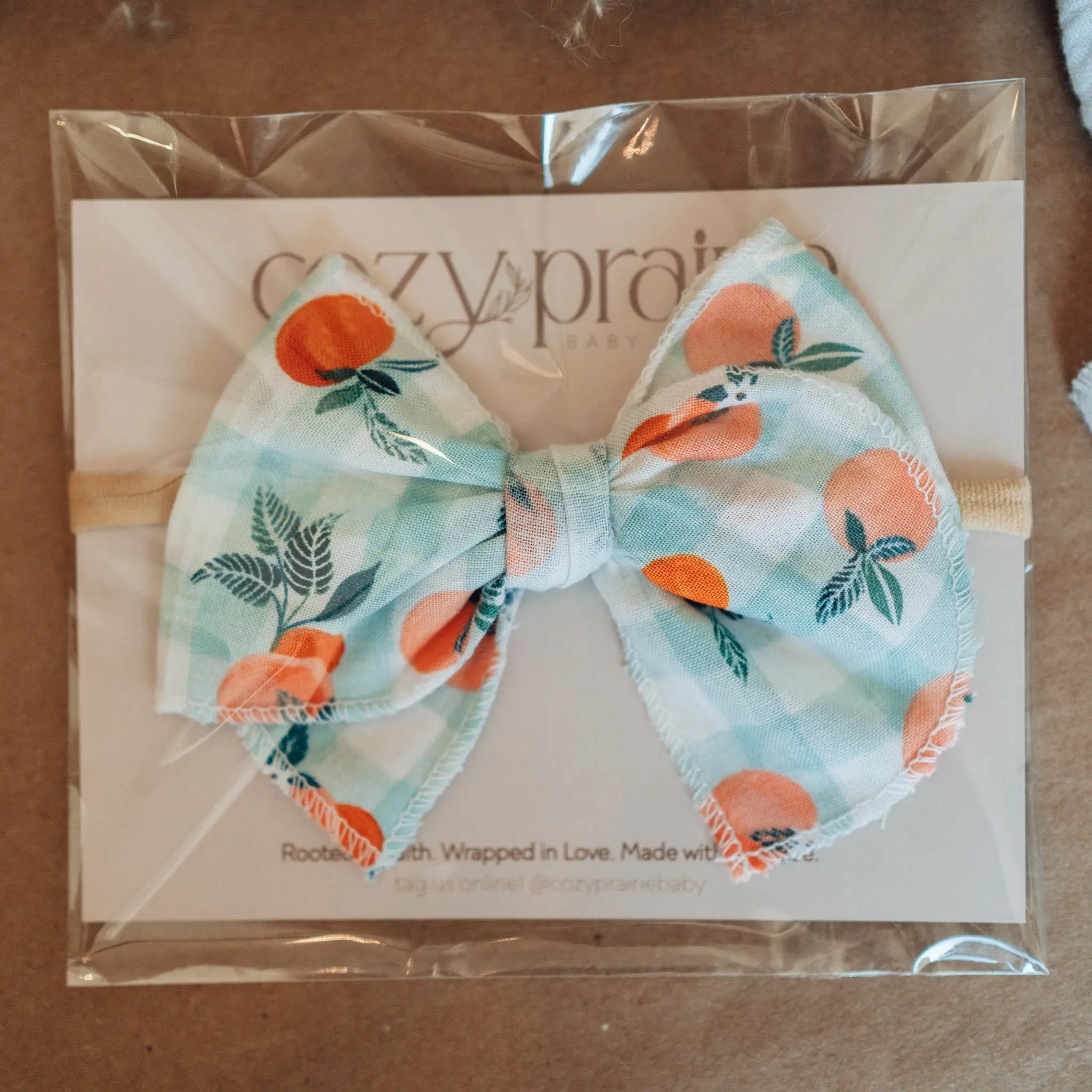 Peach-patterned bow tie in packaging on a brown surface