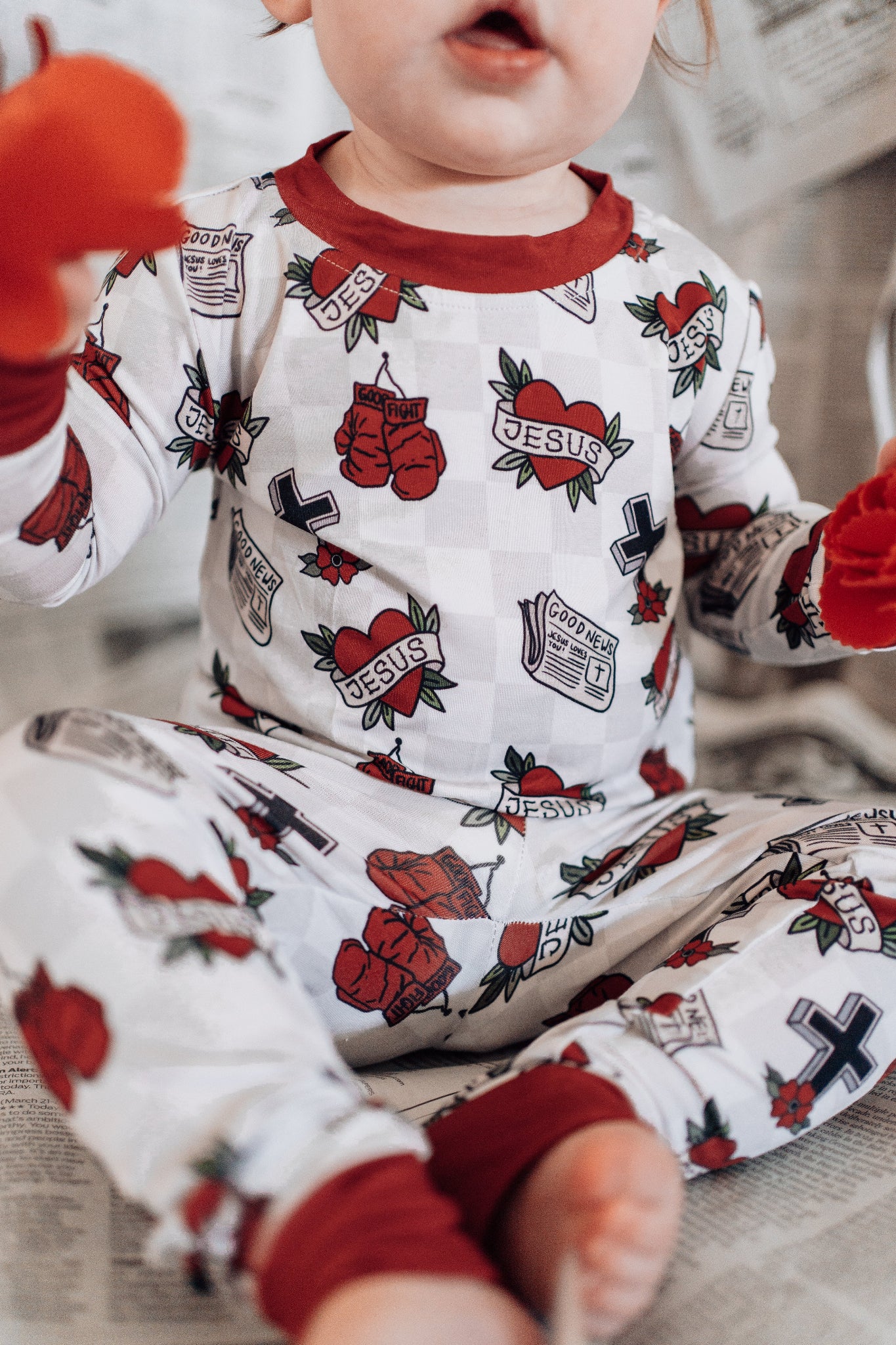 Child wearing pajamas with tattoo-themed design on a neutral background