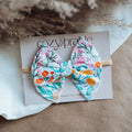Floral hair bow on a cardstock with Cozy Prairie branding.