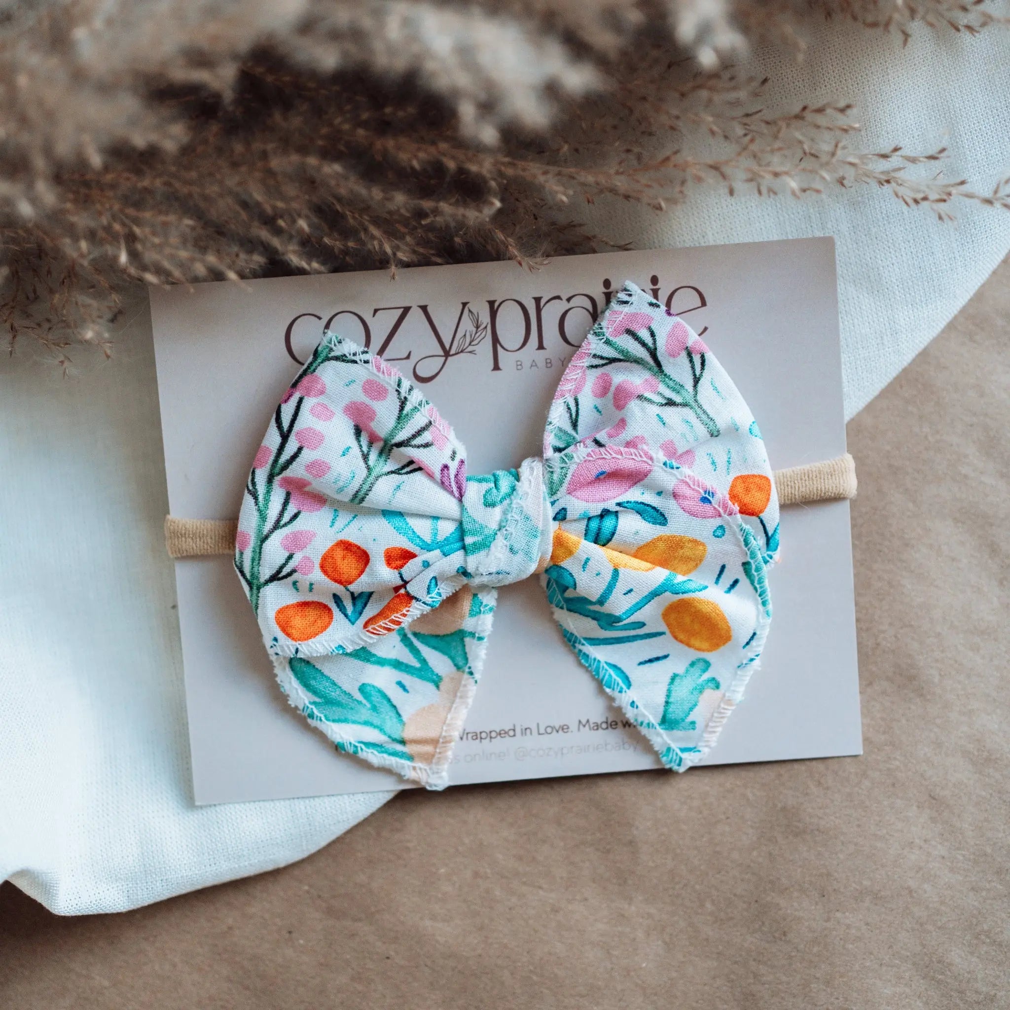 Floral hair bow on a cardstock with Cozy Prairie branding.